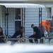 People sit on the porch of a house on Greenlawn Ave. that was shot at earlier in the morning on Wednesday, August 21, 2013. Melanie Maxwell | AnnArbor.com